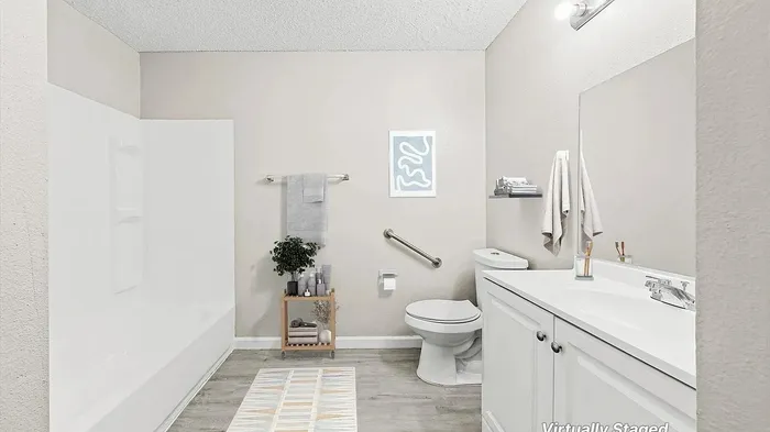 Elegant bathroom with modern fixtures, featuring a sleek white vanity, stylish shelving, and cozy decor. Virtually staged to inspire luxury living.