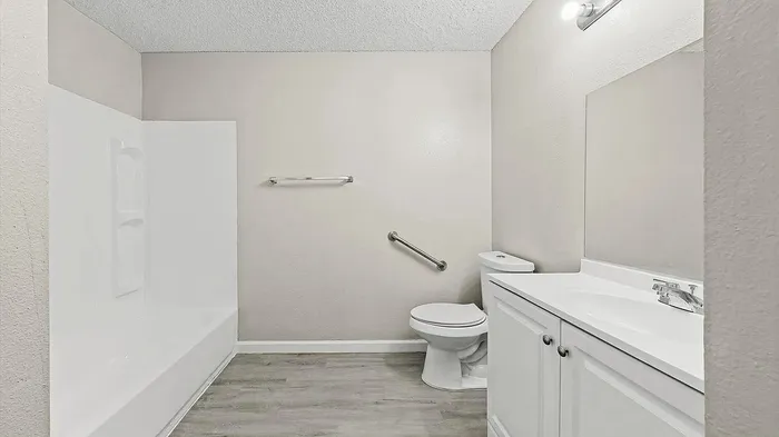 Bright, modern bathroom featuring a sleek bathtub, elegant vanity, and stylish flooring.