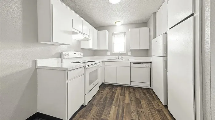 Bright and airy modern kitchen featuring sleek white cabinets, stylish countertops, and elegant wood flooring.