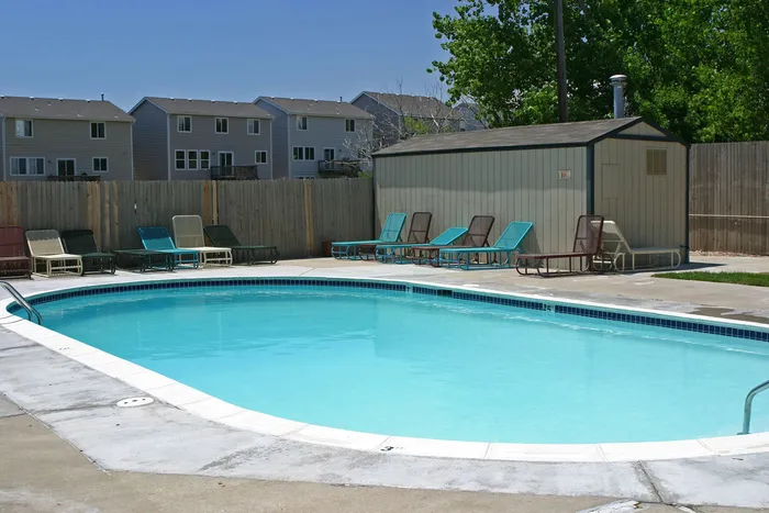 Charming outdoor pool area with inviting lounge chairs and serene surroundings, perfect for relaxation.