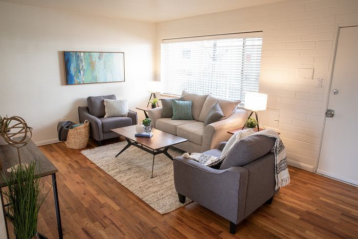 Bright and welcoming living room with modern furniture, hardwood floors, and large window for natural light.