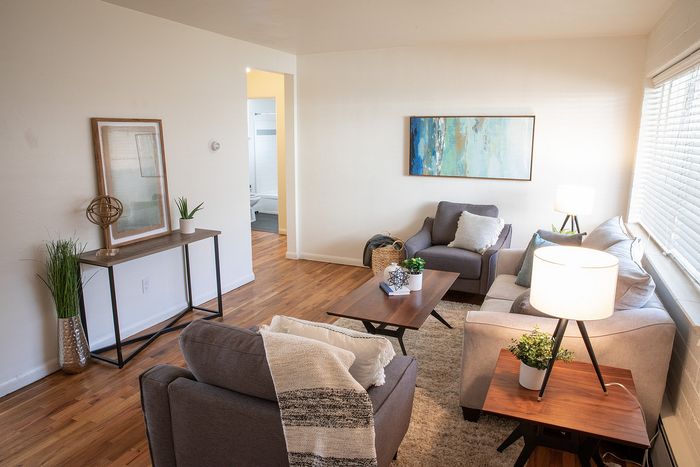 Bright and inviting living room with modern furnishings, featuring cozy sofas, stylish decor, and abundant natural light.