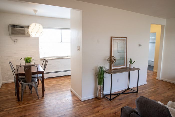 Charming apartment interior with a cozy dining area, stylish hardwood floors, and modern minimalist decor. Bright and inviting atmosphere.