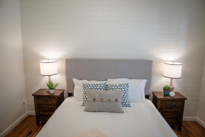 Cozy bedroom with elegant decor featuring a plush bed, stylish pillows, and warm bedside lighting.