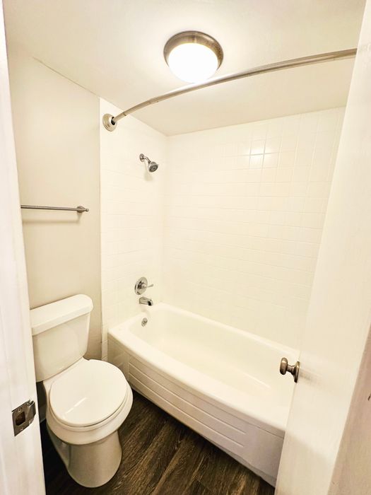Modern bathroom featuring a sleek bathtub, stylish tiles, and efficient lighting.