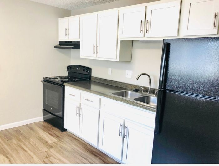 Modern kitchen with sleek black appliances, spacious countertops, and white cabinetry offering a clean, contemporary look.