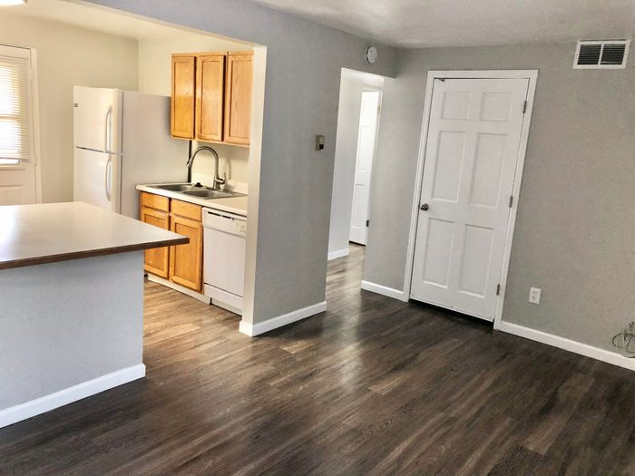 Modern kitchen with sleek wooden cabinetry, spacious countertops, and gleaming hardwood floors, offering a bright and inviting space.