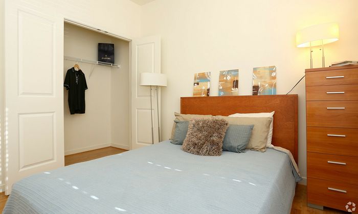 Inviting bedroom with a soft blue bedspread, wooden headboard, and stylish decor accents.