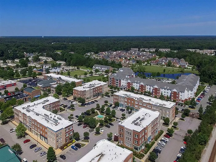 Aerial view of a modern residential community with multiple apartment complexes and lush green surroundings.