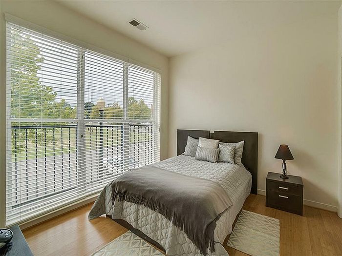 Inviting bedroom with a cozy bed, elegant decor, and large windows offering a scenic view.
