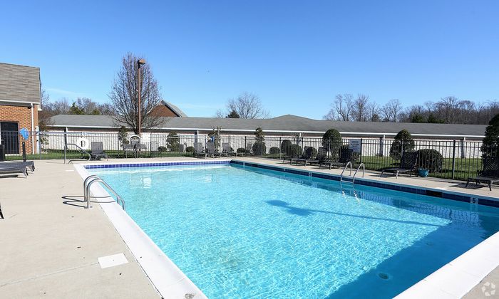 Inviting outdoor pool area with sunbeds under a clear blue sky, ideal for relaxation and leisure.