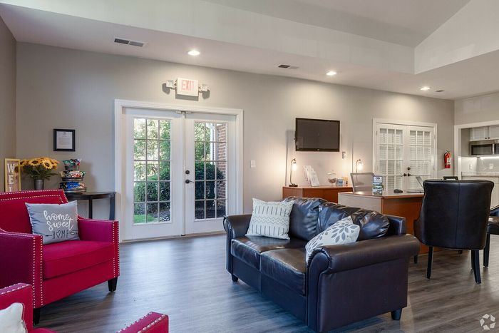 Inviting living room with stylish armchairs, a cozy sofa, and modern decor in front of glass doors.
