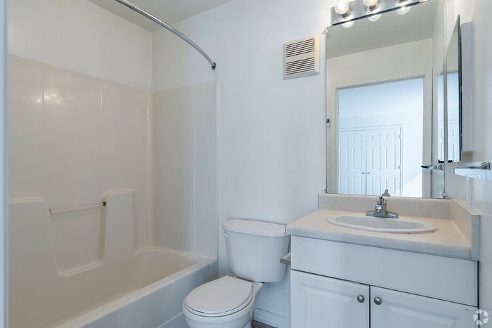 Bright and modern bathroom featuring a sleek bathtub, classic sink, and large mirror.