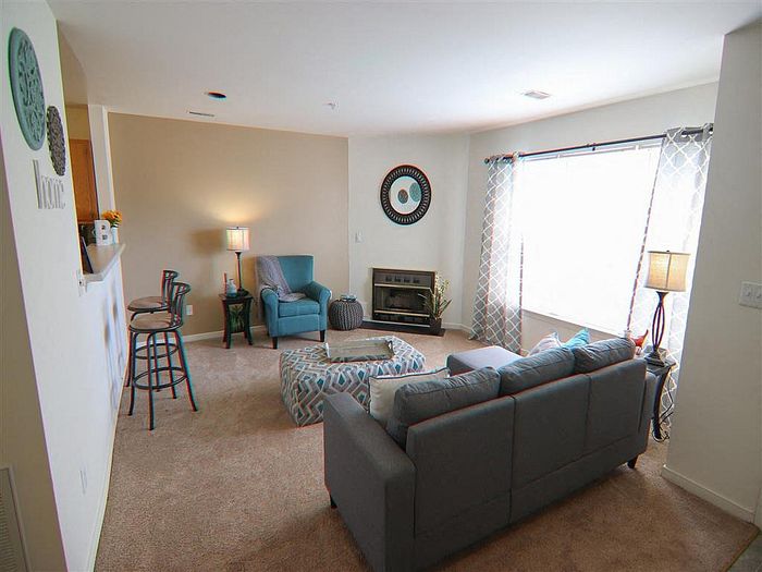 Inviting living room with modern furniture, large window, and warm lighting.