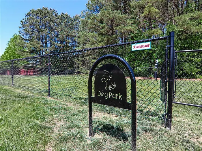 Inviting dog park with a fenced area surrounded by lush greenery.