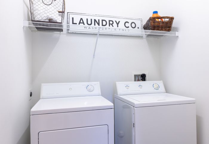 Modern laundry area featuring a washer and dryer set with stylish storage solutions.
