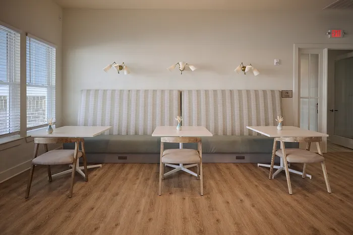 Stylish dining area with modern seating, wooden floors, and ambient lighting.