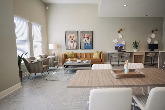Stylish living room with modern furniture, featuring artwork of dogs in suits and a cozy workspace.