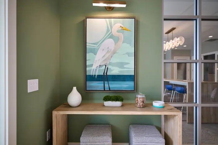 Charming corner nook with a stylish bird painting, modern wooden table, and cozy seating.