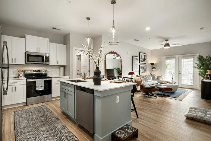 Modern open-concept kitchen with a stylish island and a cozy living area with natural light and elegant decor.