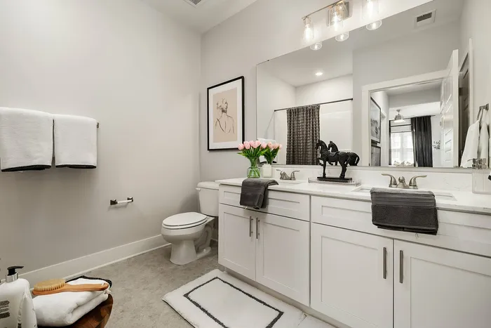Luxurious bathroom featuring dual sinks, modern decor, and elegant lighting.