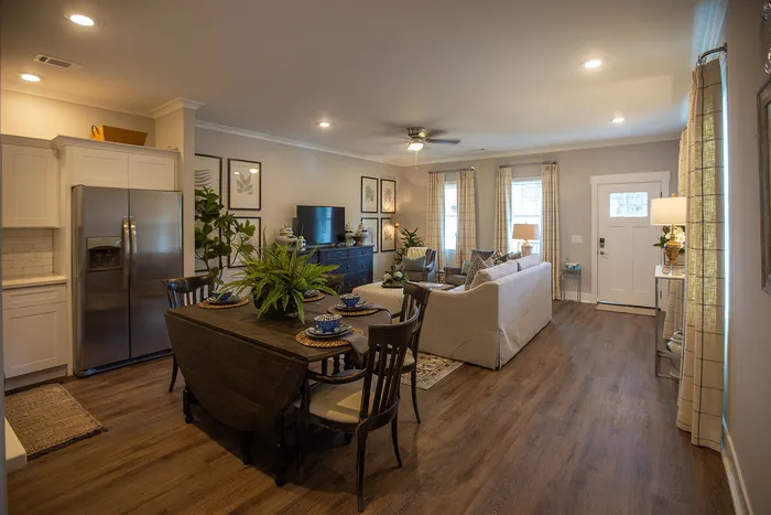 Elegant open-plan living and dining area with modern decor, featuring a stylish dining table, lush indoor plants, and cozy seating for relaxing ambience.