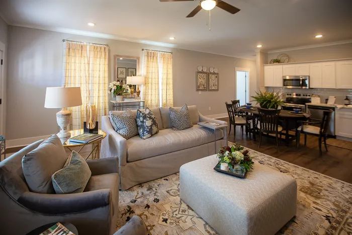 Elegant open-concept living and dining area featuring plush seating, contemporary decor, and a modern kitchen.