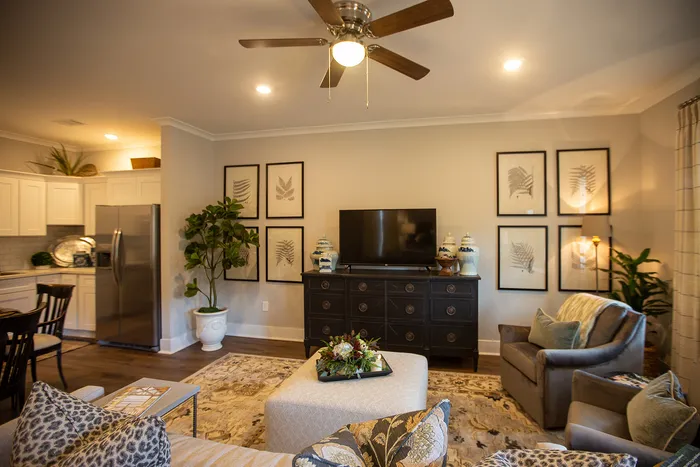 Elegant living room with plush seating, stylish decor, and an open kitchen design, featuring bright lighting and modern finishes.