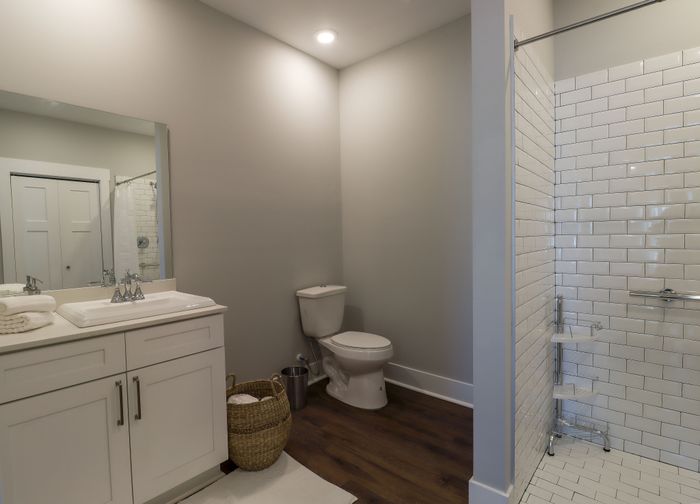 Elegant bathroom with sleek vanity, modern fixtures, and stylish subway tile shower offering a serene retreat.