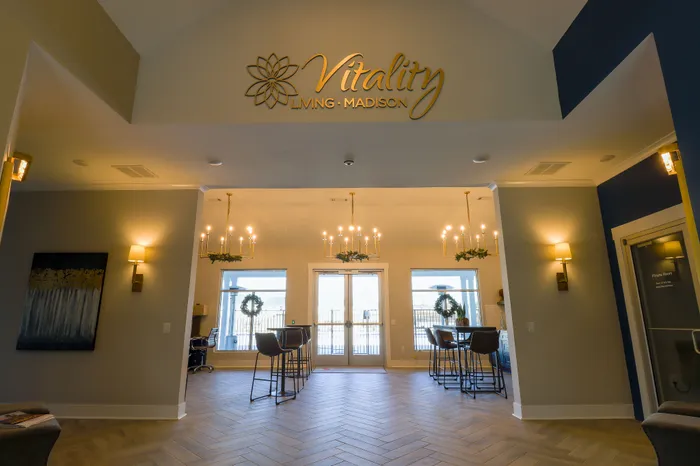 Inviting community space with elegant chandeliers, high ceilings, and stylish seating at Vitality Living Madison.