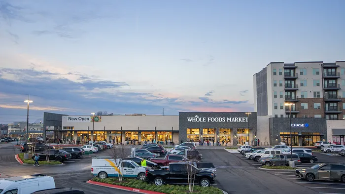 Chic urban living at its finest with a Whole Foods and Chase Bank set against modern architecture, offering convenience and style in a vibrant neighborhood.