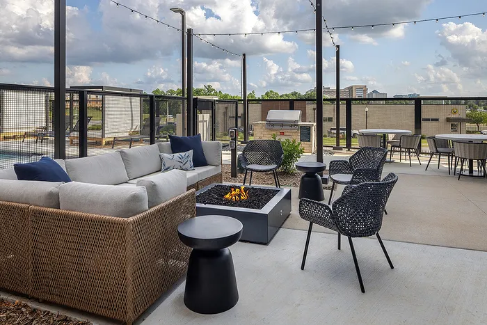 Chic outdoor lounge with cozy fire pit, comfortable seating, and scenic views of the city.
