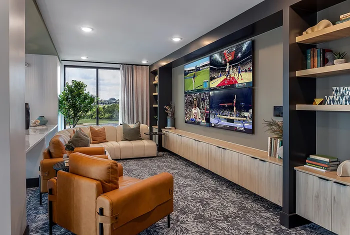 Luxurious living room with plush seating, large multi-screen entertainment wall, and modern decor, offering a perfect blend of comfort and style.