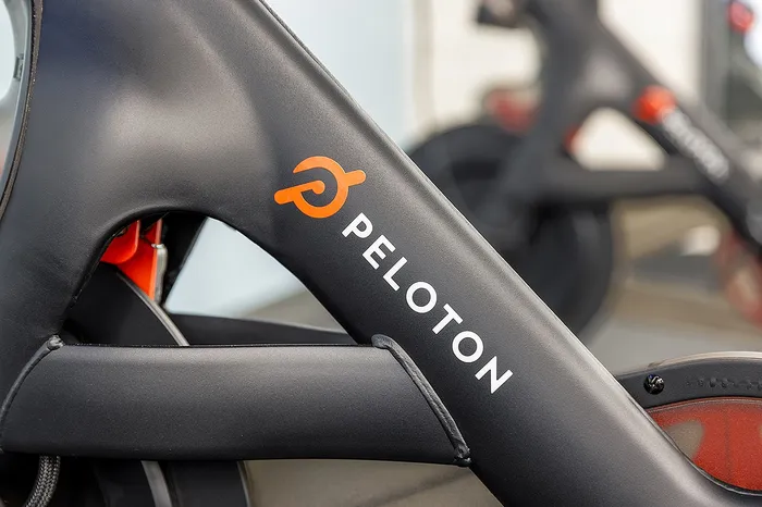 Sleek close-up of a modern exercise bike, showcasing the stylish Peloton logo and premium design.