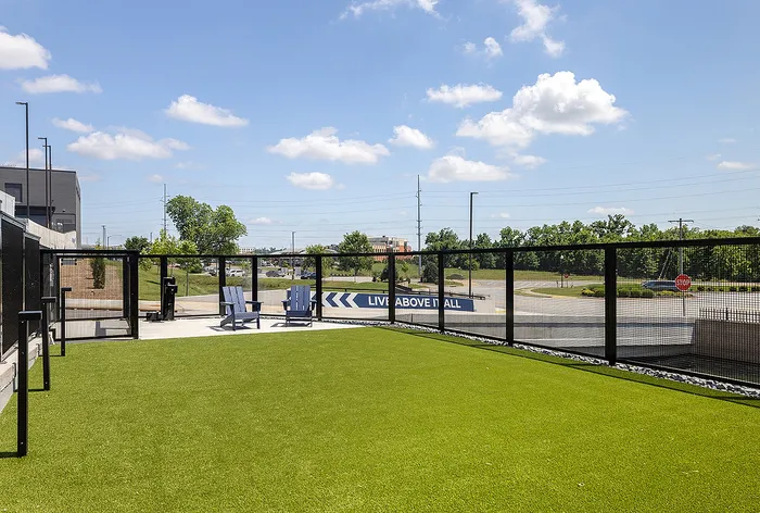 Modern outdoor space with lush green lawn, stylish seating, and expansive view showcasing a 'Live Above It All' ambiance.