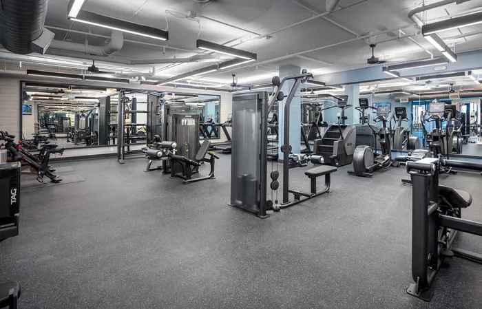 Modern fitness center equipped with state-of-the-art exercise machines and sleek, spacious design for an invigorating workout experience.