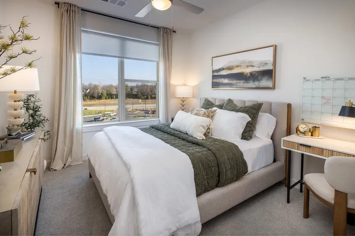 Bright and cozy bedroom with elegant decor, featuring a plush bed, stylish artwork, and scenic window view.