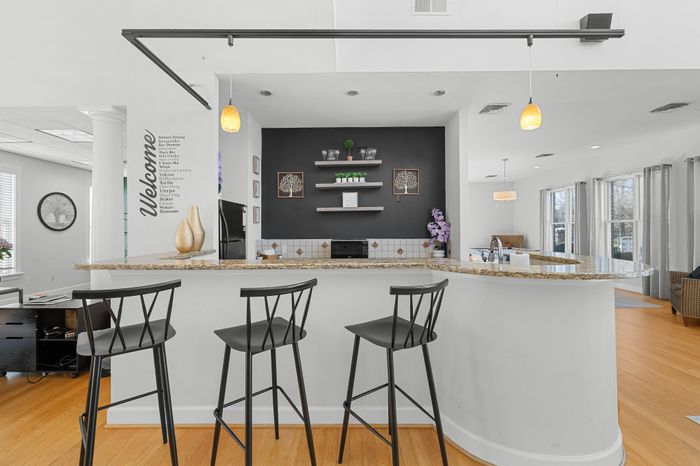 Modern open-concept kitchen with elegant bar seating, stylish pendant lighting, and a welcoming ambiance.