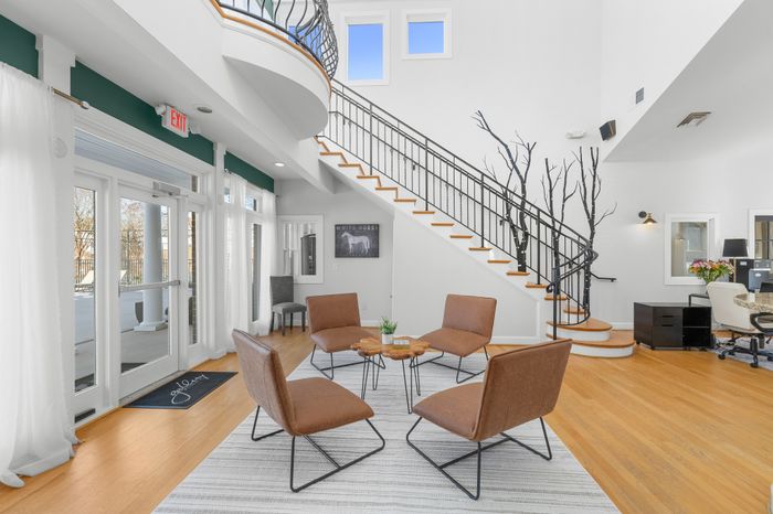 Bright, modern lobby with elegant staircase and stylish seating area, perfect for relaxation and welcoming guests.