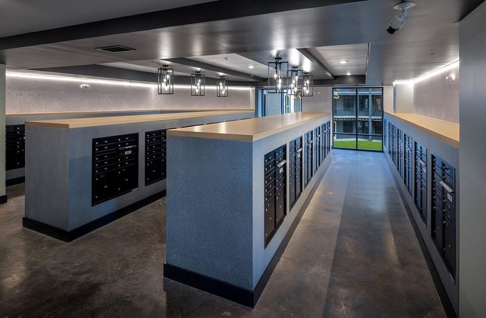 Contemporary apartment mailroom featuring sleek design with modern lighting and expansive windows.