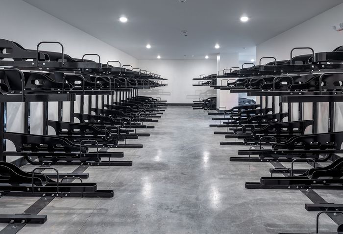 Spacious bike storage area with sleek black racks and polished concrete floors, offering abundant storage for cyclists.