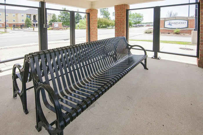Inviting outdoor seating area with elegant black metal bench, offering a perfect spot to relax and enjoy the surrounding scenery.