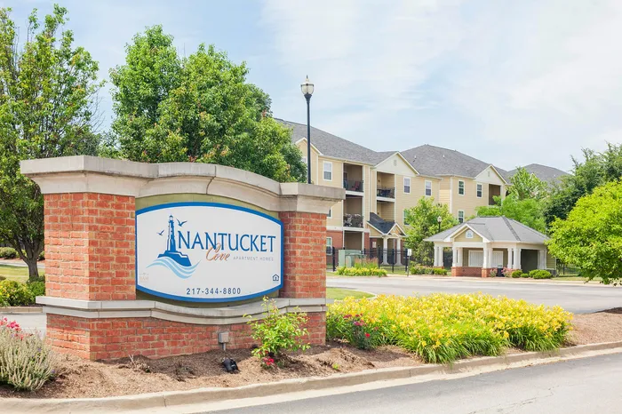 Charming Nantucket Cove Apartment Homes entrance with vibrant landscaping and inviting architecture.