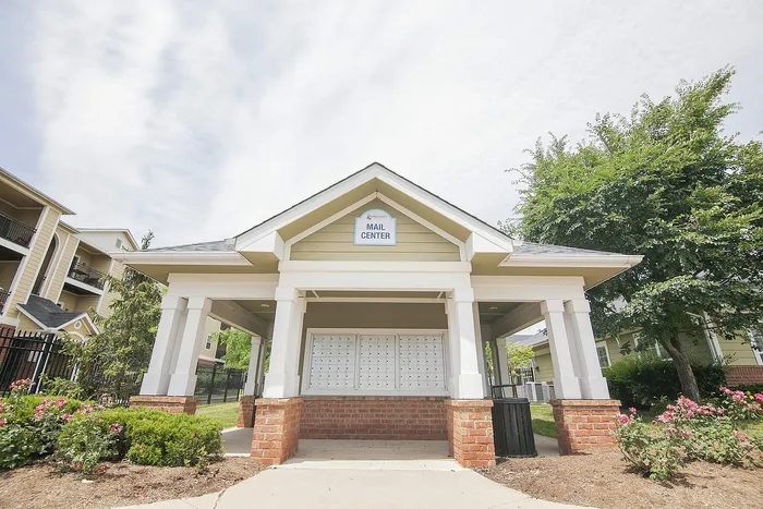 Charming apartment mail center with brick accents and lush landscaping, enhancing community living.