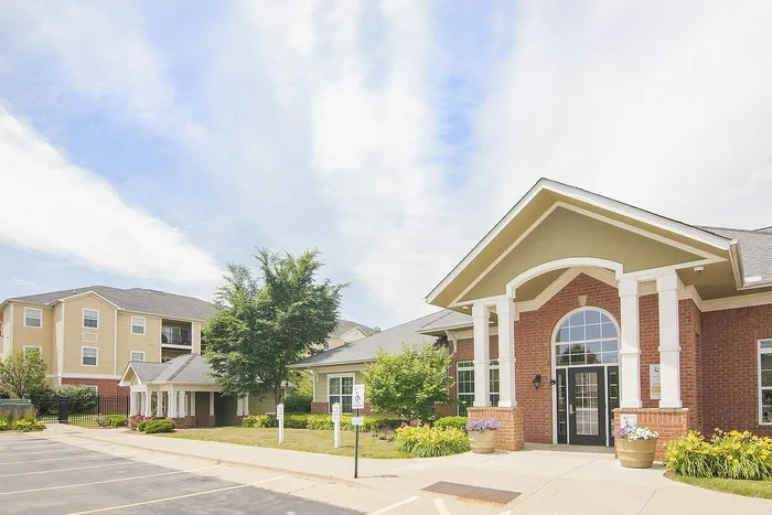 Charming apartment complex with elegant brick facade, surrounded by lush landscaping and modern amenities.