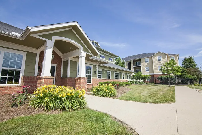 Charming community building with modern architecture surrounded by vibrant landscaping on a sunny day.