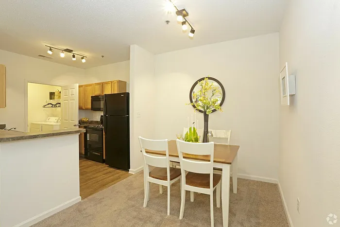 Bright and inviting dining area with elegant wooden table, modern kitchen appliances, and cozy lighting, perfect for family gatherings.