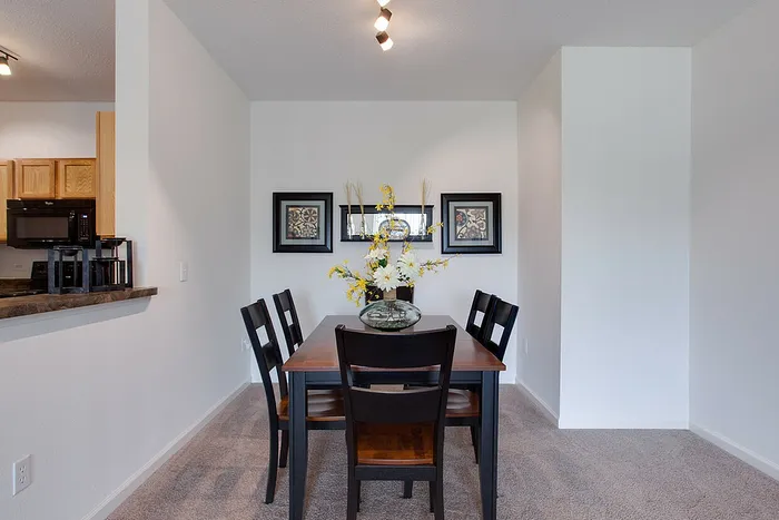 Elegant dining area with a modern table set, vibrant floral centerpiece, and framed art, perfect for stylish gatherings.