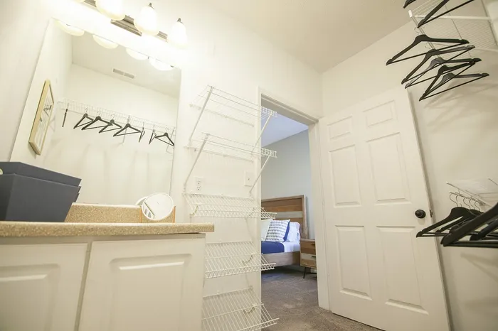 Bright and spacious walk-in closet with ample shelving and stylish hangers, steps away from a cozy bedroom.