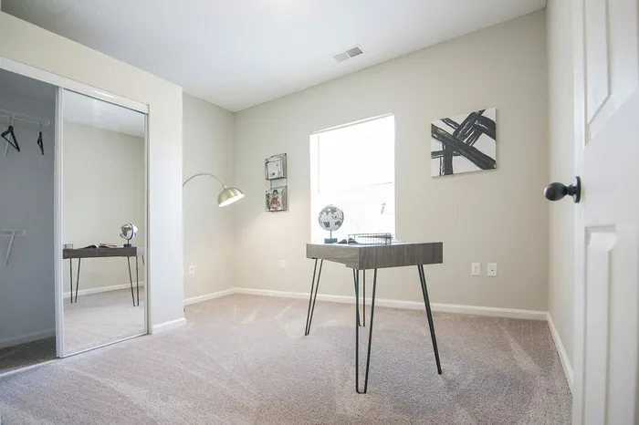 Bright and modern home office with sleek desk, contemporary lamp, and ample natural light, ideal for productivity and focus.